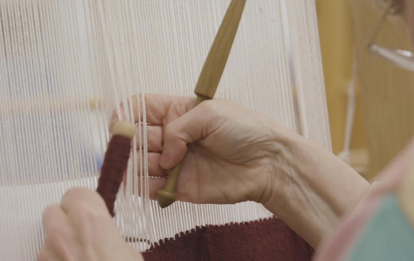 Detail of threads being woven into a tapestry